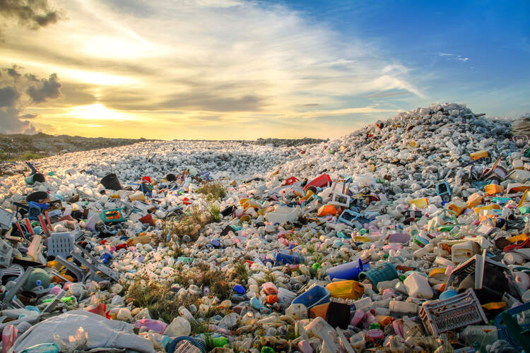 Resíduos plásticos empilhados em um lixão ao ar livre.